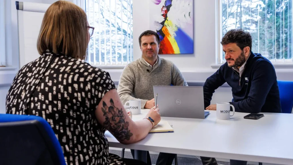 Accountants from Modus sitting around a table in the Abingdon office discussing tax.